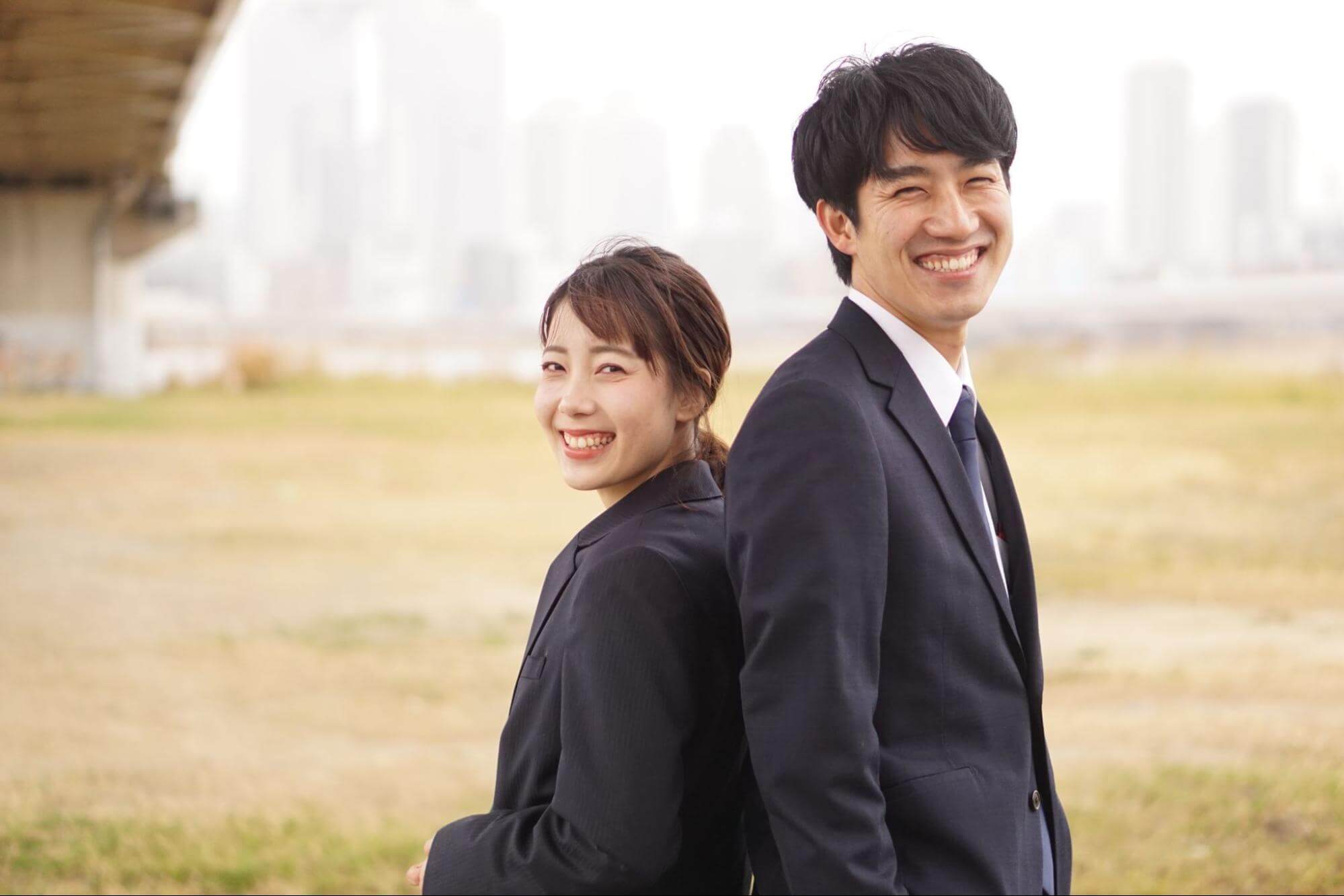 見出し「大企業志向だけではない！就活生が企業に求めること」のイメージ画像。背中合わせで立つスーツ姿の就活生男女