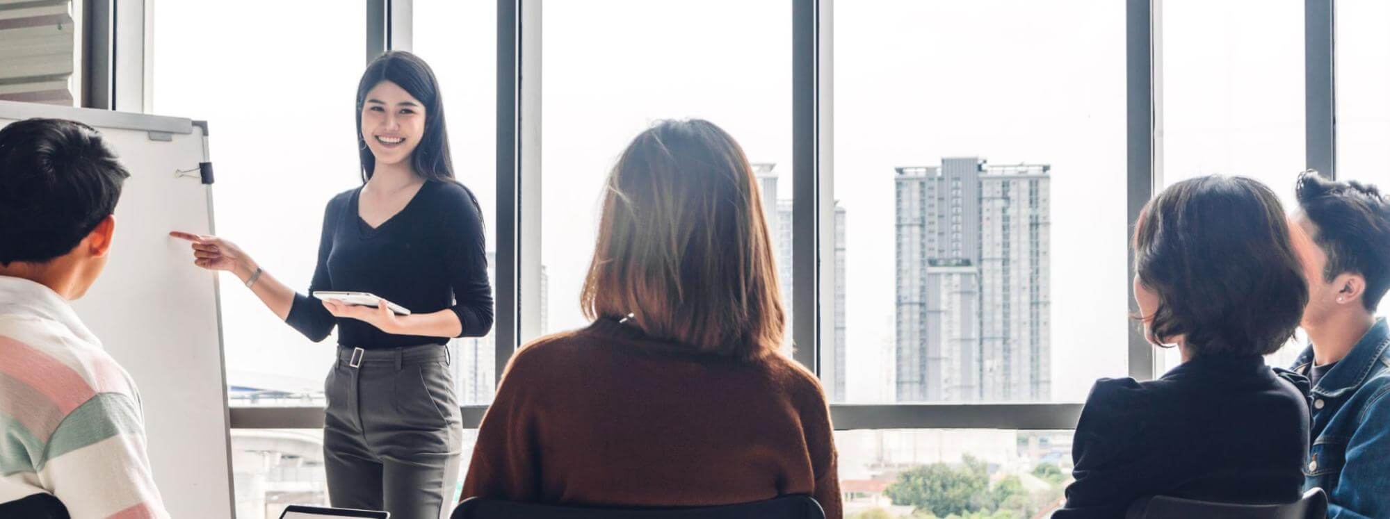 オフィスで女性がプレゼンテーションを行っている画像