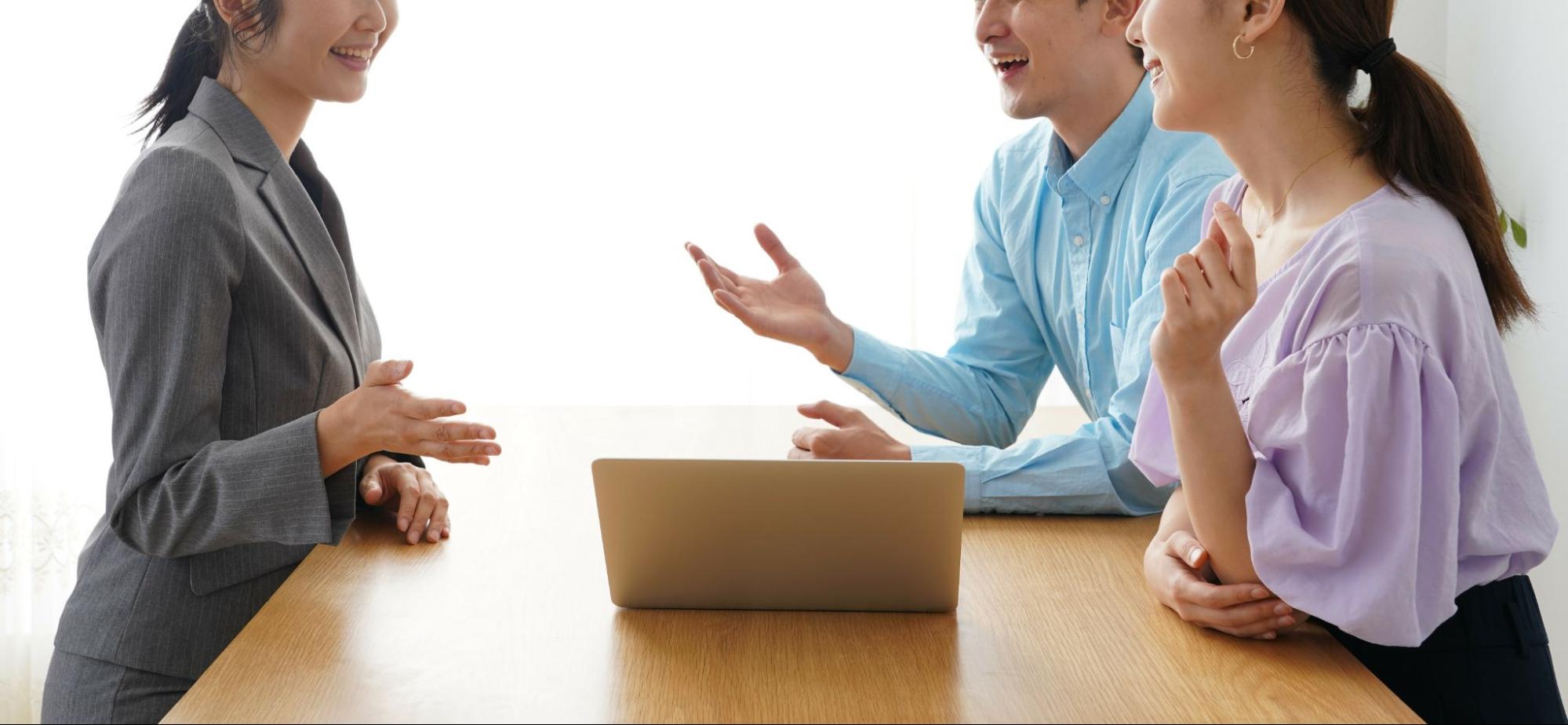 営業マンとカップルが座って話す様子