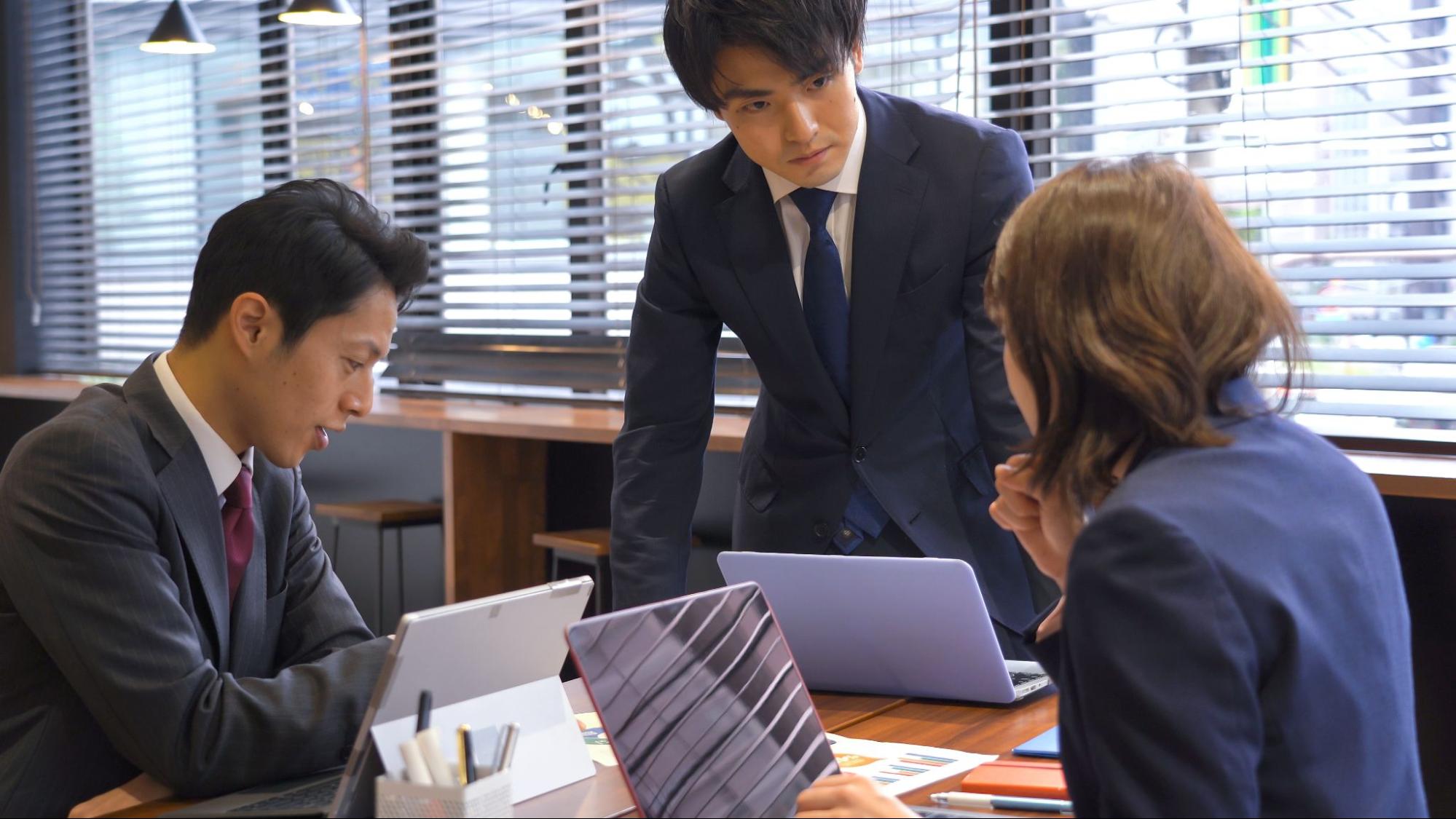 3人のビジネスパーソンが話し合いをする様子